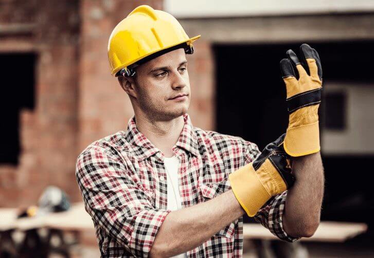 Técnico de segurança do trabalho vestindo luvas de proteção.